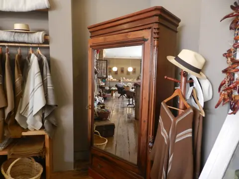 Artisan shop interior with handwoven ponchos, straw hats and strings of dried chillies