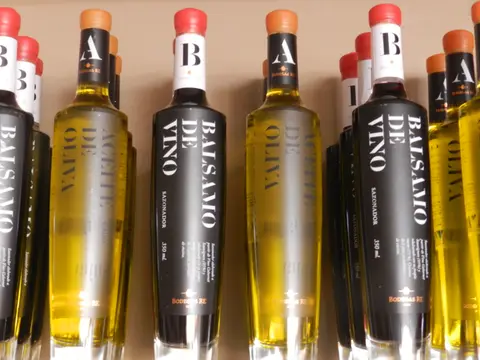 Bottles of Bodegas RE olive oil and wine balsamic vinegar lined up on a shelf