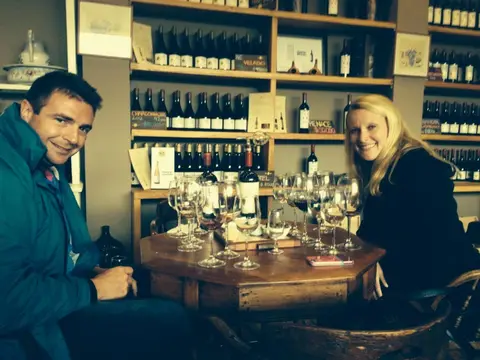 Couple seated at a round table with a flight of wine glasses in the Bodegas RE tasting room