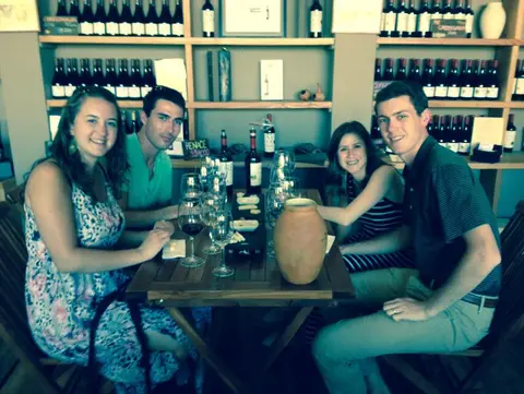 Four guests at a tasting table beside a clay amphora in the Bodegas RE tasting room
