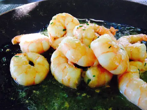 Prawns cooked in garlic and olive oil, served sizzling in a cast-iron pan