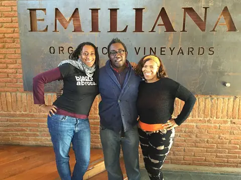 Three guests standing in front of the Emiliana Organic Vineyards sign in the Casablanca Valley