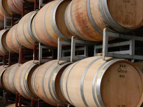 Rows of French oak barrels stencilled Viña Quintay, stacked on steel racks in a barrel hall
