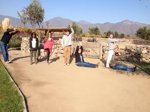 Group of guests posing playfully on a winery path with mountains behind