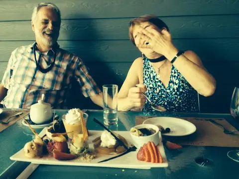 Couple laughing over a shared dessert platter at a winery restaurant
