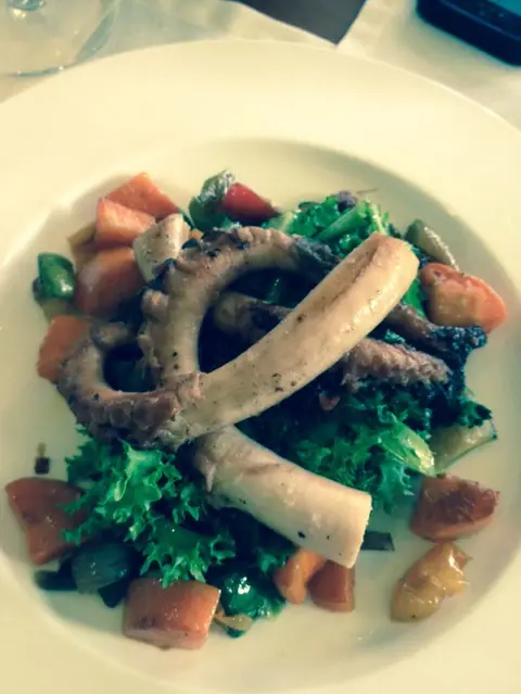 Grilled octopus served on a warm vegetable salad at a winery restaurant