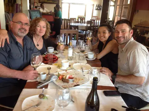 Group of four at the end of lunch in a winery restaurant, dessert plates cleared